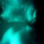 An evocative underwater portrait featuring light effects and motion blur.