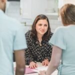Realtor talking with clients about buying a new home. Indoor consultation scene.